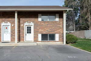 View of front facade with brick siding and uncovered parking