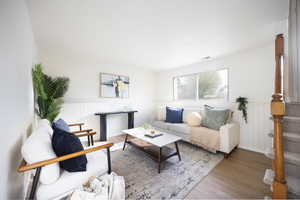 Living area with wood finished floors and wainscoting
