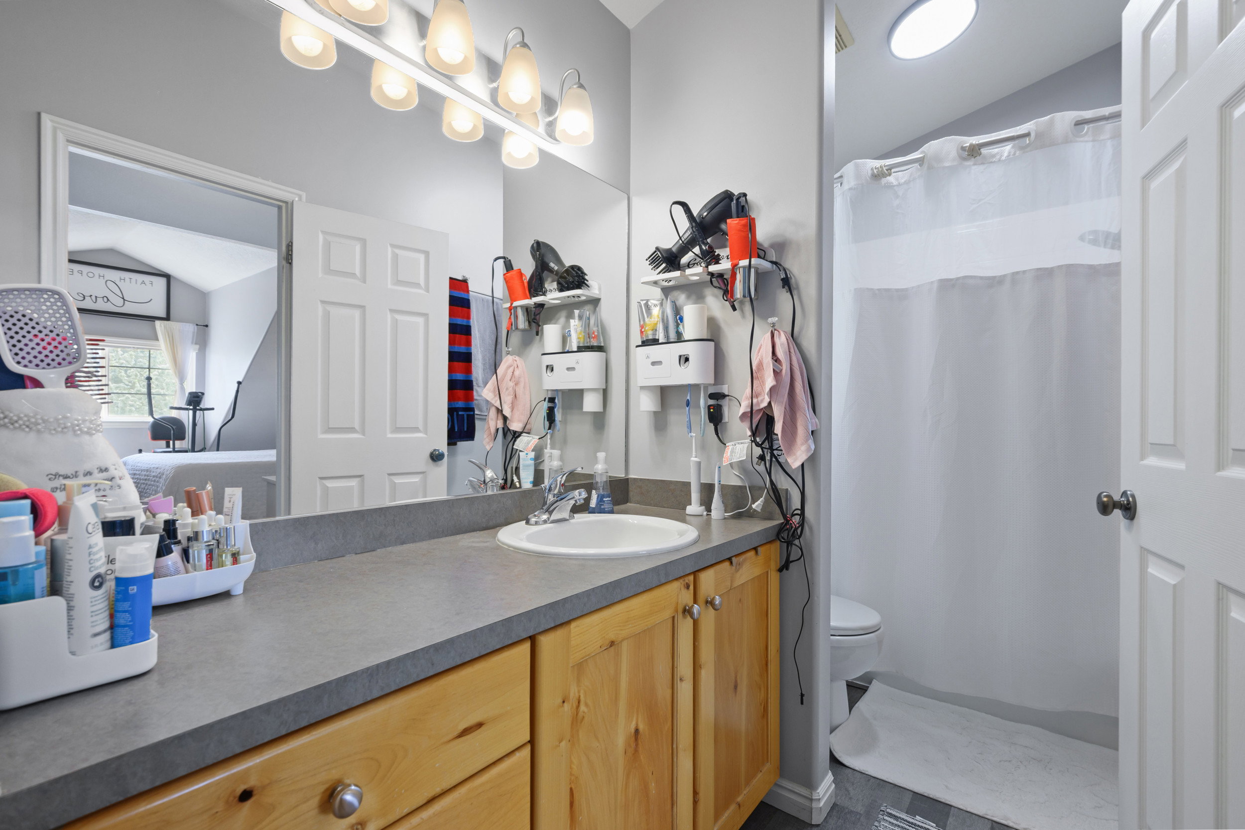 Full bathroom featuring a shower with shower curtain, vaulted ceiling, and vanity