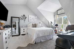 Bedroom featuring light colored carpet and lofted ceiling