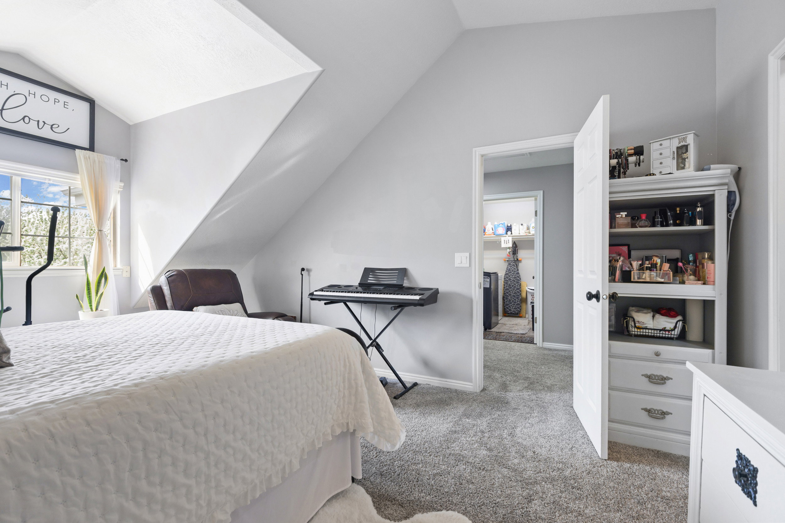 Bedroom with light colored carpet and vaulted ceiling