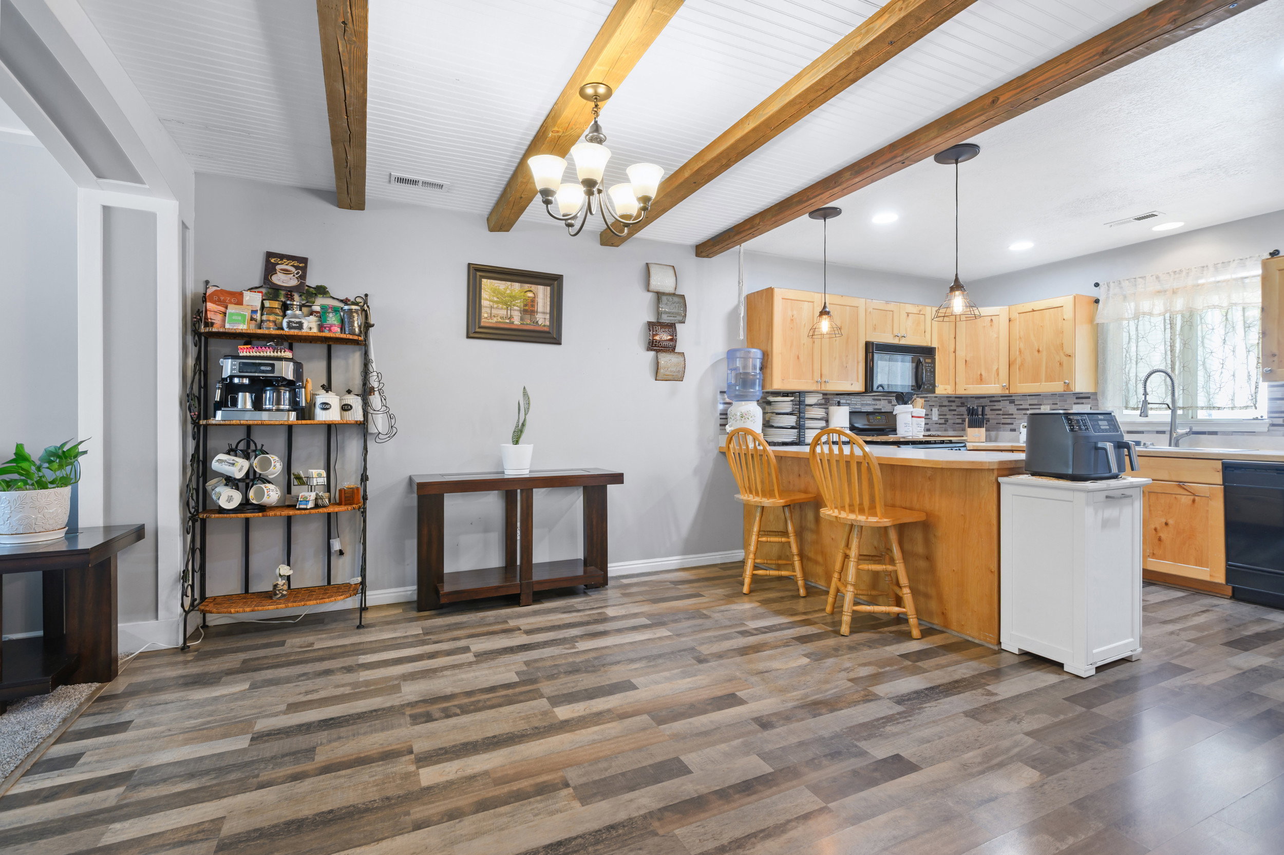 Kitchen featuring a breakfast bar, decorative backsplash, a peninsula, hanging lights, and light countertops