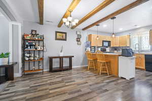 Kitchen featuring a breakfast bar, decorative backsplash, a peninsula, hanging lights, and light countertops