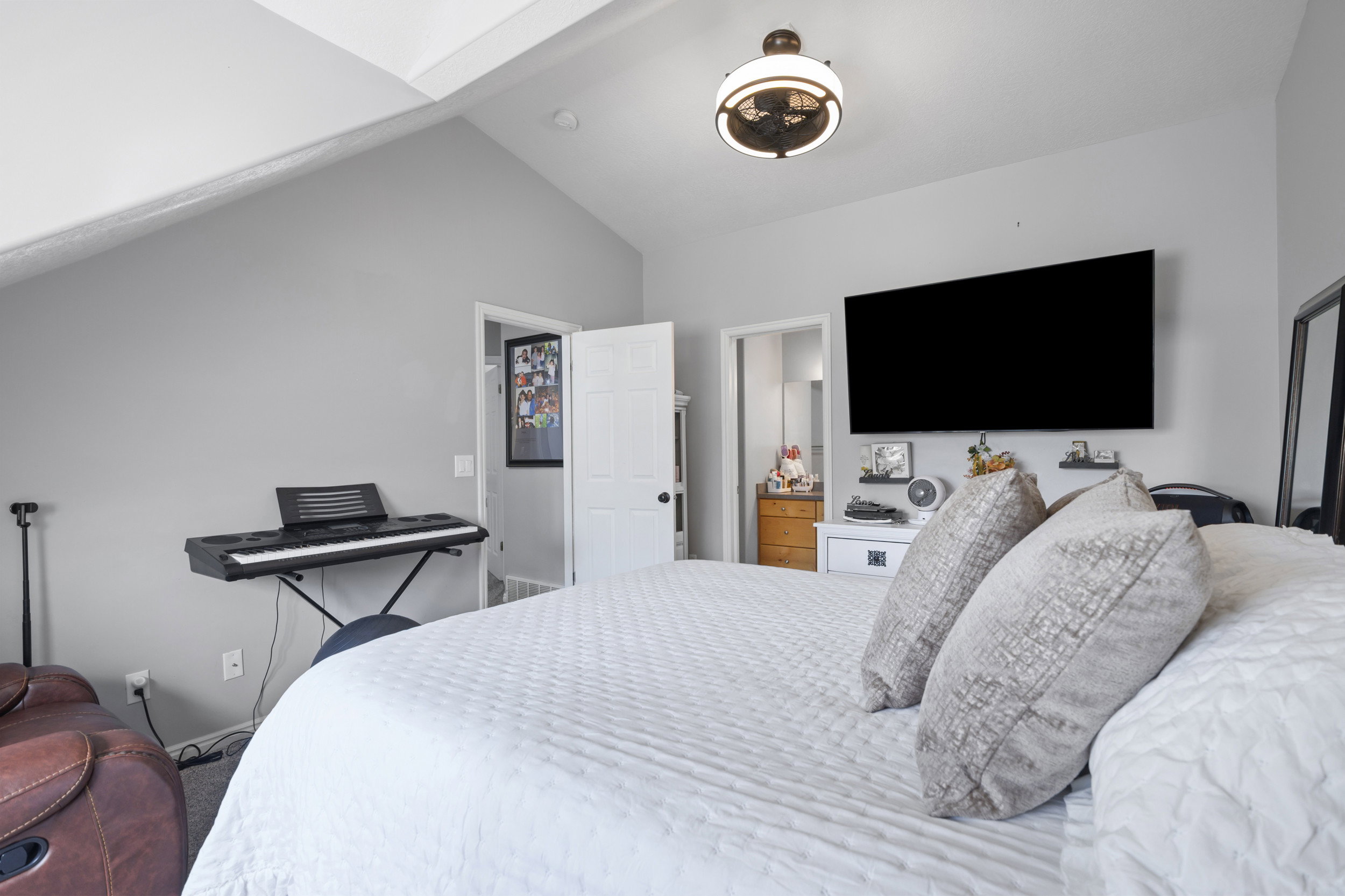 Bedroom featuring lofted ceiling and ensuite bath