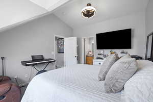 Bedroom featuring lofted ceiling and ensuite bath