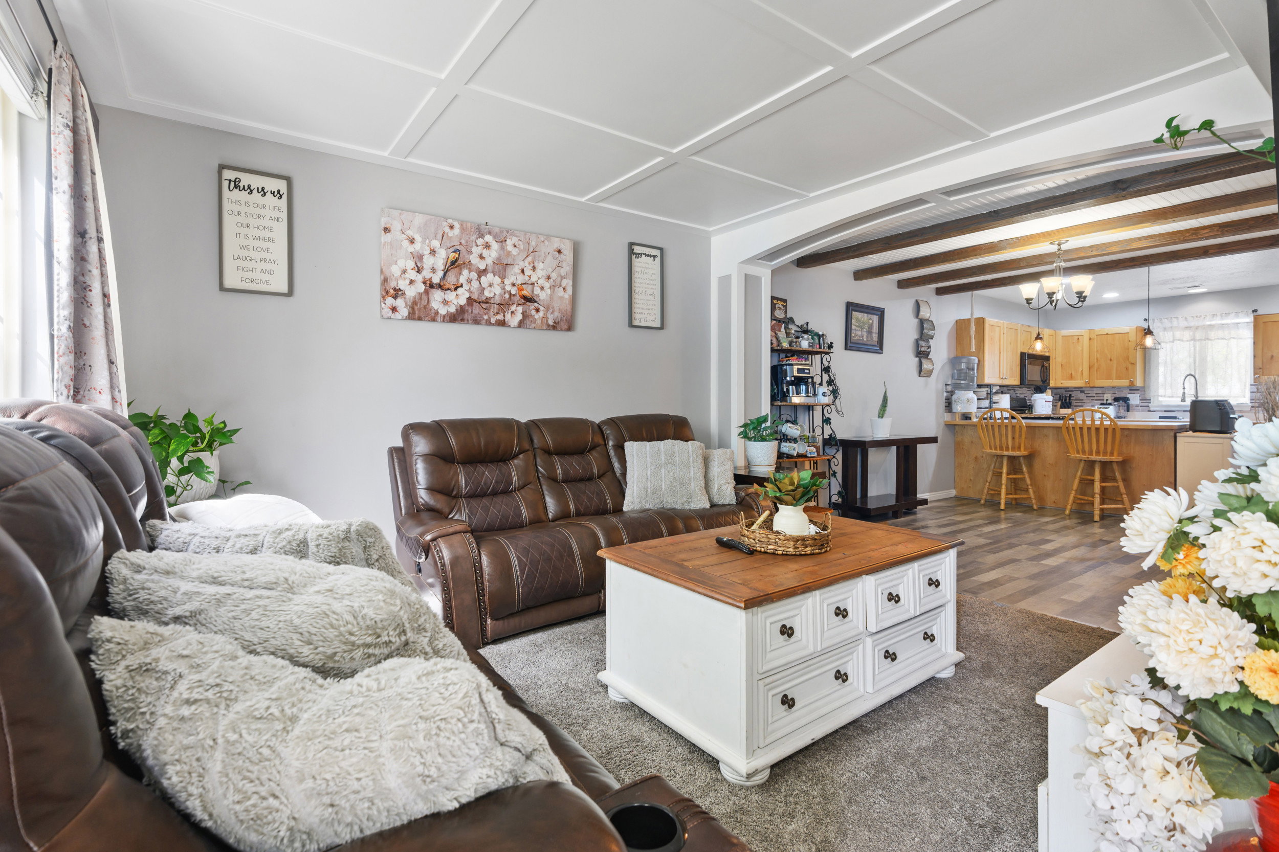 Living area with hanging lights, beamed ceiling, and arched walkways