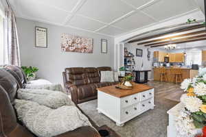 Living area with hanging lights, beamed ceiling, and arched walkways