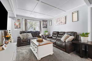 Living room featuring carpet and coffered ceiling