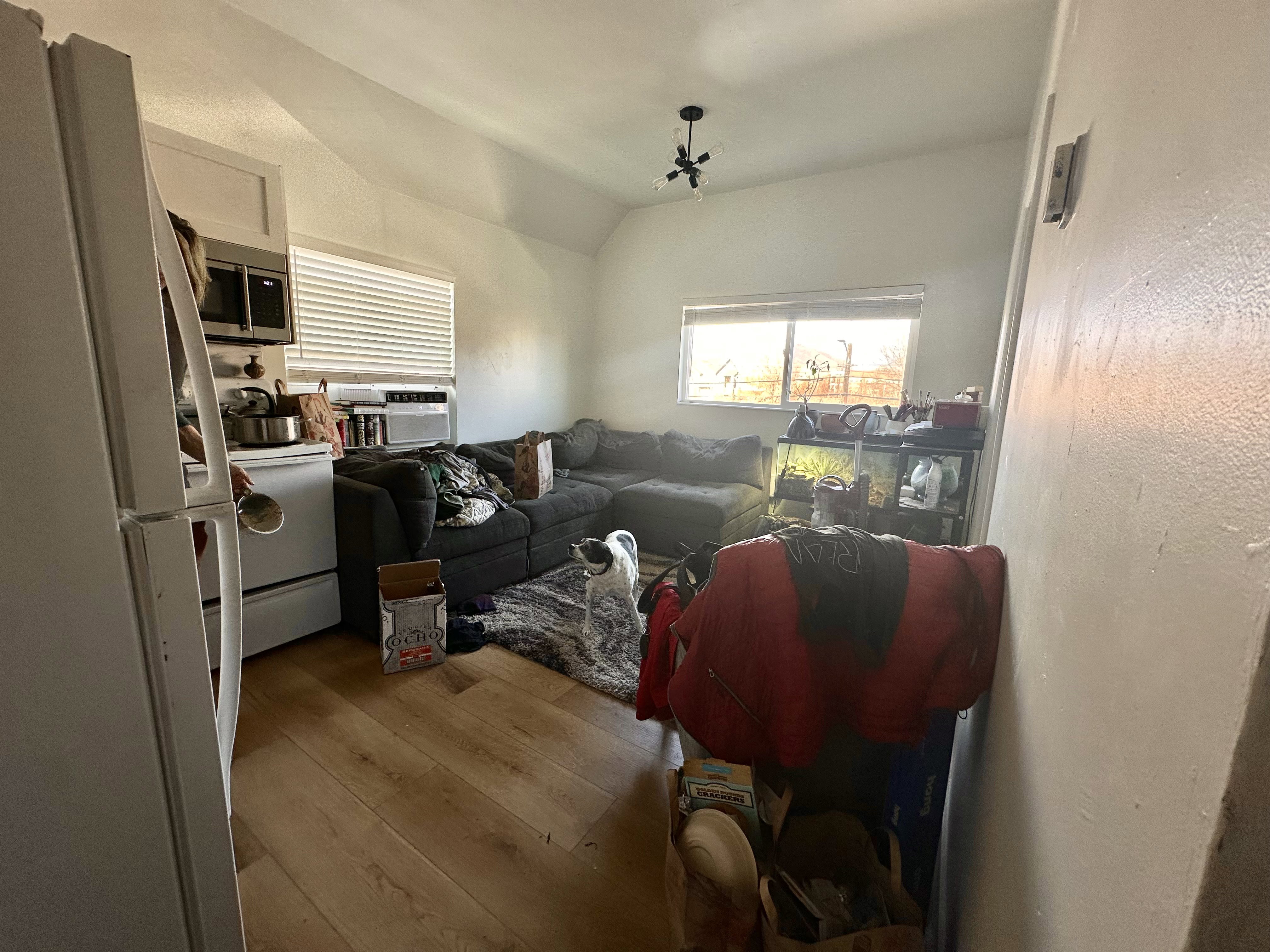Living area with light wood-type flooring, vaulted ceiling, and cooling unit