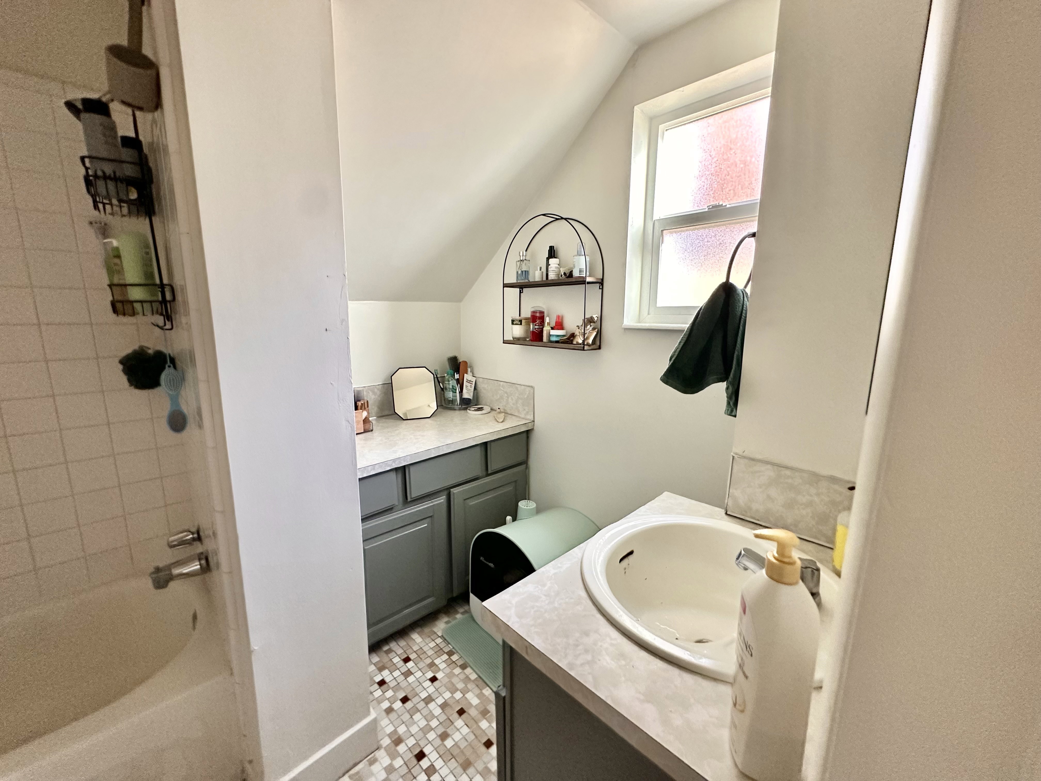 Full bath featuring vanity, bathing tub / shower combination, lofted ceiling, and light tile patterned flooring