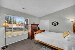 Bedroom featuring dark wood-type flooring and baseboards