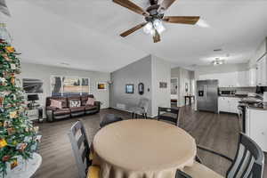 Dining space with dark wood-type flooring and ceiling fan