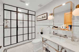 Full bathroom with tile walls, walk in shower, recessed lighting, tile patterned flooring, and a wainscoted wall