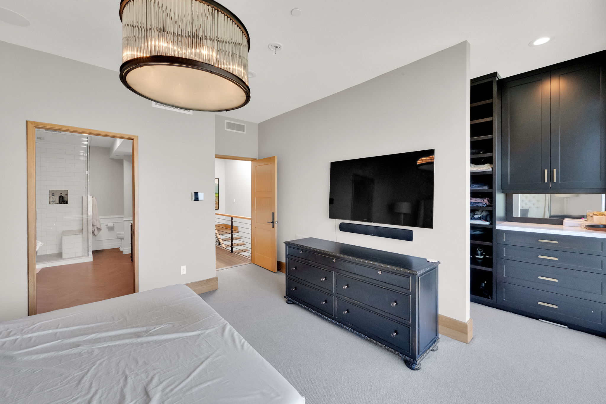 Bedroom featuring light colored carpet and ensuite bath