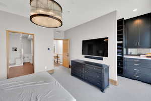 Bedroom featuring light colored carpet and ensuite bath
