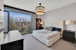 Bedroom with light carpet, expansive windows, and recessed lighting