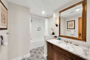 Bathroom with vanity, light tile patterned floors, tiled shower / bath combo, and recessed lighting