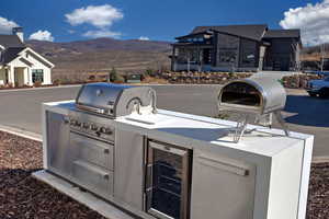 View of patio / terrace with beverage cooler, a mountain view, and area for grilling