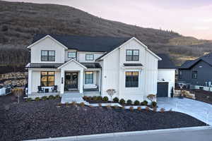 View of front of property with board and batten siding, concrete driveway, a standing seam roof, and covered porch