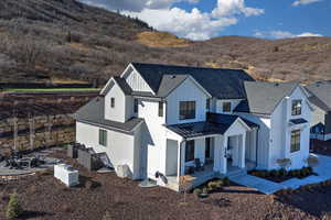 Modern farmhouse with covered porch, board and batten siding, a mountain view, roof with shingles, and a standing seam roof