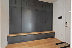 Mudroom featuring light wood-style flooring and baseboards