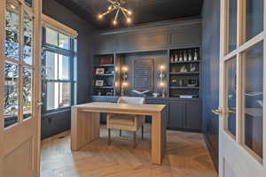 Office with parquet flooring and built in features