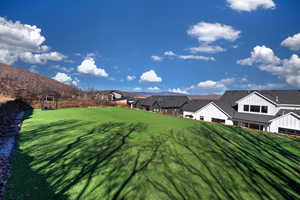 View of green lawn featuring a mountain view