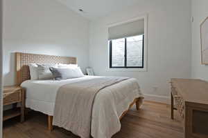 Bedroom featuring wood finished floors and baseboards