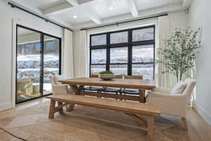 Dining room with light wood-style flooring, healthy amount of natural light, recessed lighting, and coffered ceiling