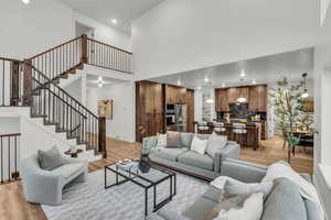 Living room with light wood-style flooring, recessed lighting, and a high ceiling
