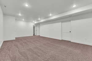 Finished basement featuring recessed lighting and dark colored carpet
