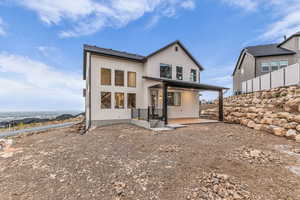 Rear view of house with a patio area and stucco siding