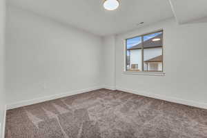 Empty room featuring baseboards and carpet floors