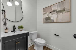 Half bathroom with vanity and wood finished floors