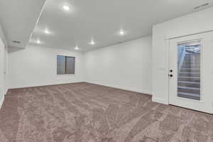 Empty room with recessed lighting and dark carpet