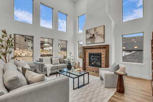 Living room featuring a fireplace, wood finished floors, and a high ceiling