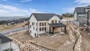 Rear view of house with a patio area, a residential view, a shingled roof, and stucco siding