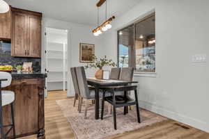 Dining space with light wood-type flooring and baseboards