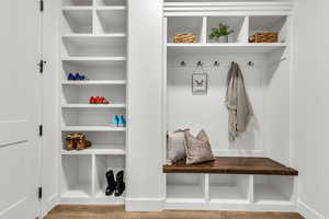 Mudroom with light wood finished floors and built in features