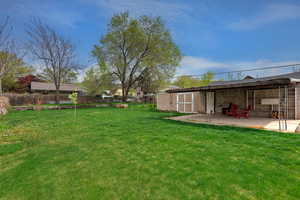 Fenced backyard featuring an outdoor structure and a patio