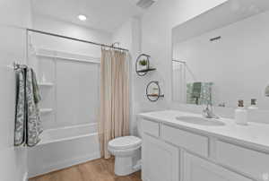Full bathroom featuring vanity, light wood finished floors, and shower / bathtub combination with curtain