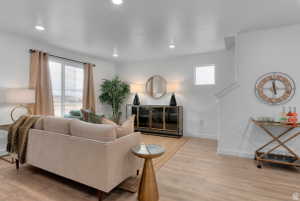 Living area with light wood-style floors and recessed lighting