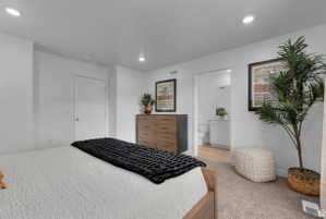 Bedroom with light carpet, recessed lighting, and ensuite bath