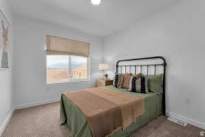Carpeted bedroom featuring baseboards and a mountain view