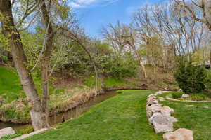 View of green lawn featuring a water view