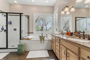 Full bathroom with a shower stall, a bath, double vanity, recessed lighting, and dark stone finish flooring