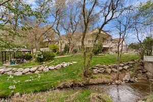 View of grassy yard with a water view and a patio area