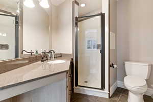 Full bathroom with a shower stall, vanity, recessed lighting