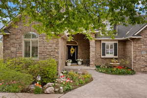 Property entrance with stone siding and roof with shingles