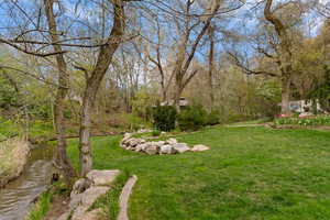 View of green lawn featuring a water view